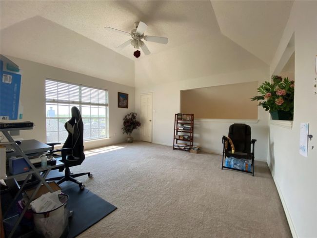 Carpeted office with a textured ceiling, ceiling fan, and vaulted ceiling | Image 38