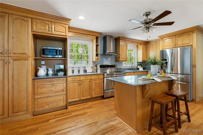 Chef's kitchen with granite counters, stainless steel appliances, ample counters and cabinet spaces and large center island | Image 12