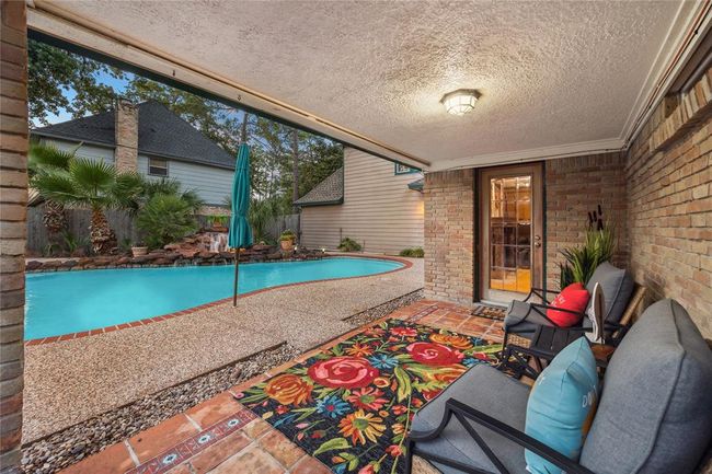 This cozy covered outdoor patio is a perfect spot for relaxation and enjoying the fresh air. | Image 30