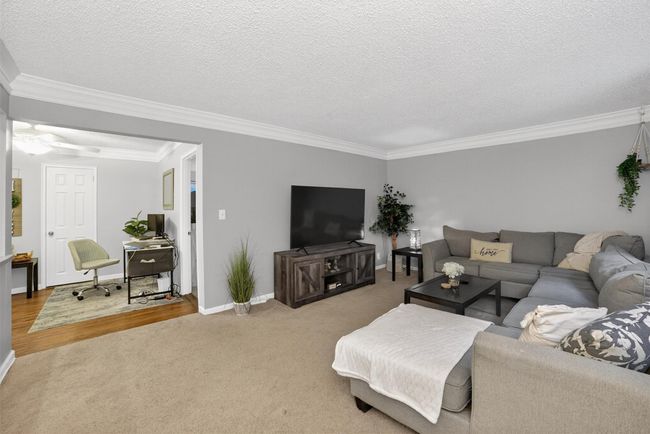 Carpeted living area with ornamental molding, a textured ceiling, and ceiling fan | Image 9