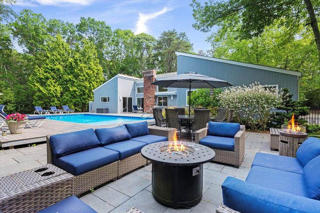 View of patio with an outdoor living space with a fire pit, an outdoor pool, and outdoor dining area | Image 32