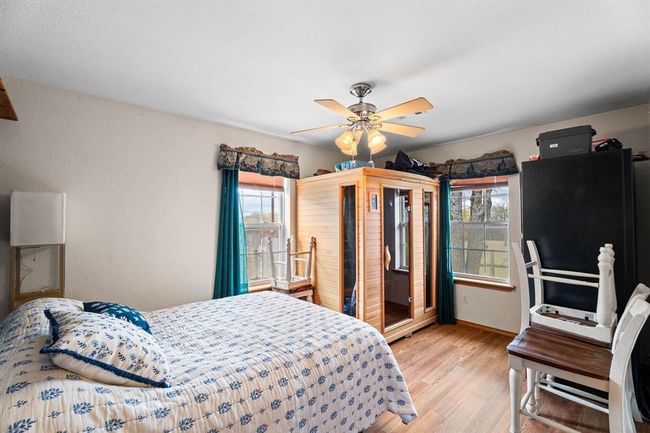 Bedroom featuring baseboards, wood finished floors, and a ceiling fan | Image 31