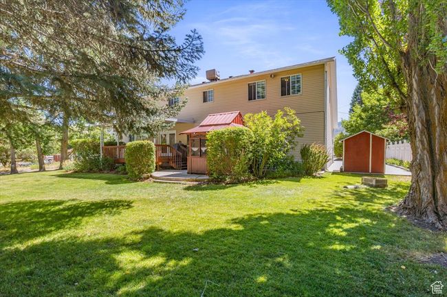 Rear view of property with a lawn, a deck, and a shed | Image 41