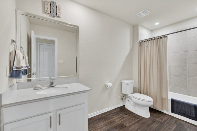 Full bathroom featuring vanity, toilet, shower / bathtub combination with curtain, visible vents, and wood finished floors | Image 31