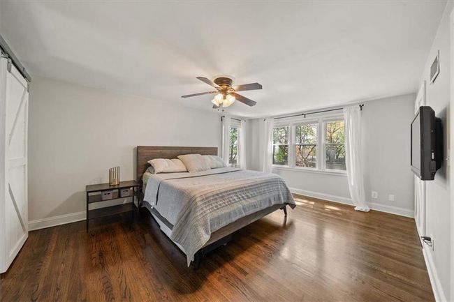 Primary Bedroom with baseboards, visible vents, wood finished floors, and a ceiling fan | Image 15