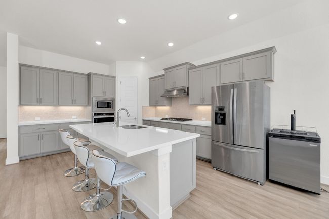 Kitchen featuring a sink, stainless steel appliances, gray cabinets, and under cabinet range hood | Image 12
