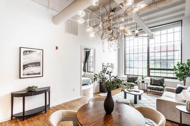 living room featuring hardwood / wood-style floors, plenty of natural light, a chandelier, beam ceiling, and a towering ceiling | Image 10