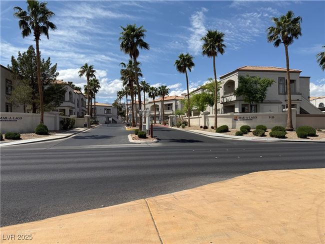 View of street featuring a residential view, sidewalks, curbs, and a gated entry | Image 12