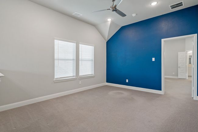 Carpeted empty room with baseboards, lofted ceiling, ceiling fan, and visible vents | Image 29