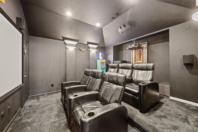 With darkened walls and a tiered layout, this enclosed media room is designed to elevate your home entertainment experience. | Image 36