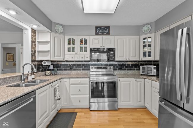 kitchen featuring open shelves and white cabinets. | Image 5