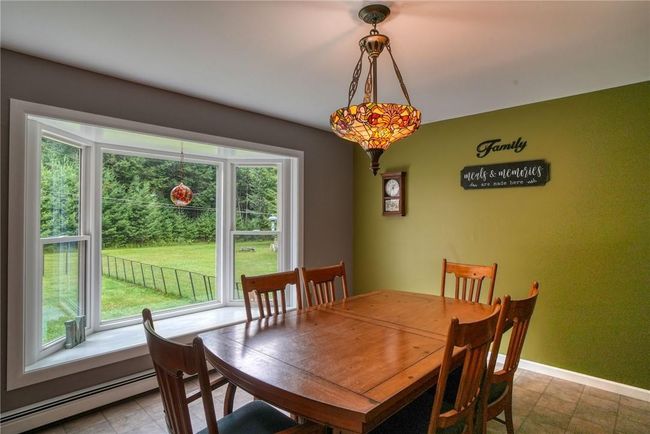 Dining area with a baseboard heating unit and a wealth of natural light | Image 14