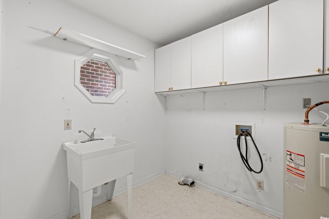 Washroom with electric water heater, cabinet space, hookup for a washing machine, and hookup for an electric dryer | Image 18