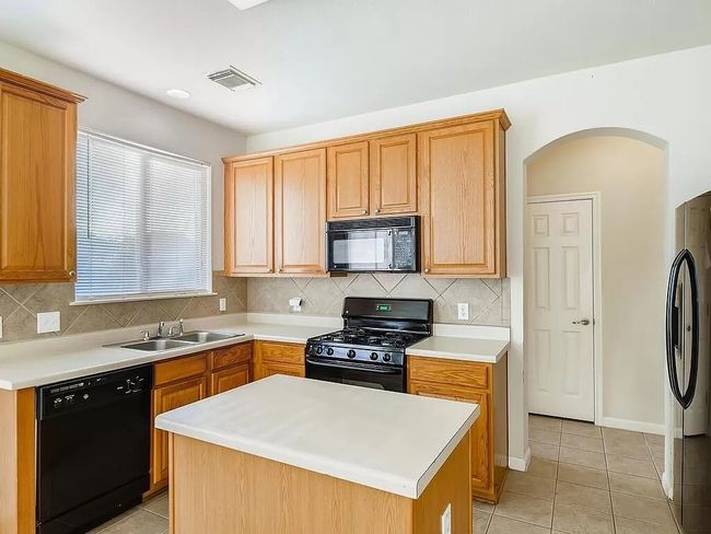 Kitchen featuring black appliances, a sink, tasteful backsplash, and light tile patterned flooring | Image 8