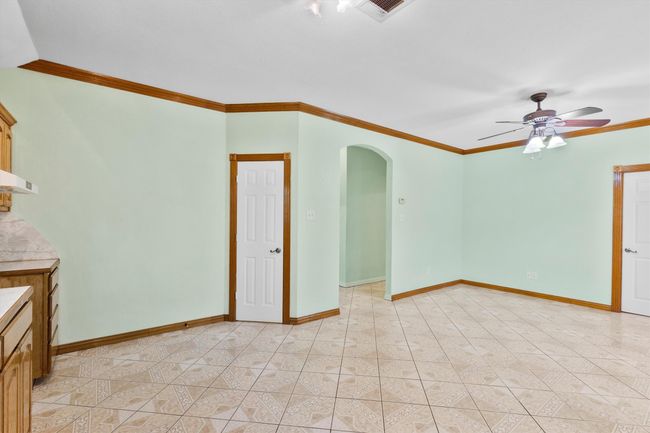 Empty room featuring arched walkways, ornamental molding, ceiling fan, and baseboards | Image 22