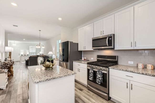 Kitchen with appliances with stainless steel finishes, light wood-style flooring, backsplash, recessed lighting, and a center island | Image 10