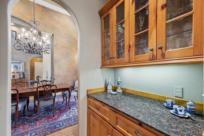 The formal dining room has direct access to this butler's pantry and the chef's kitchen for effortless serving and entertaining. This convenient space features glass-front display cabinetry, under-cabinet lighting and storage for less often used prized serving dishes. | Image 11