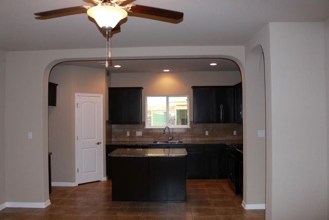 Kitchen featuring arched walkways, a sink, a kitchen island, ceiling fan, and recessed lighting | Image 4