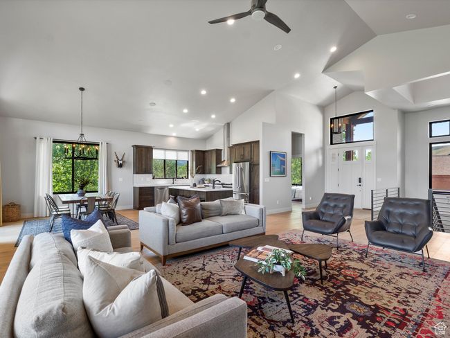 Living area with recessed lighting, plenty of natural light, a ceiling fan, high vaulted ceiling, and light wood-style floors | Image 9