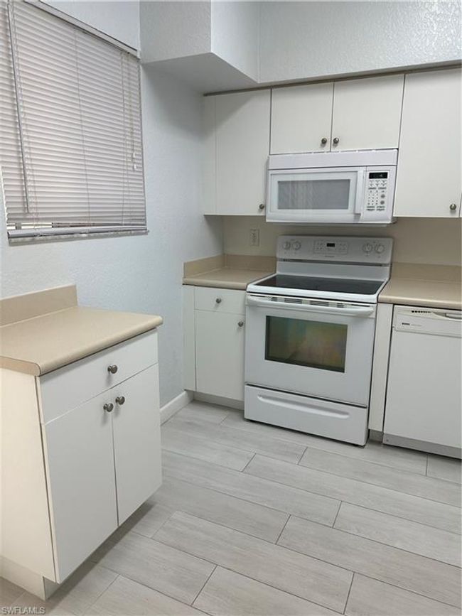 Kitchen featuring white cabinetry, white range oven, and dishwasher | Image 8
