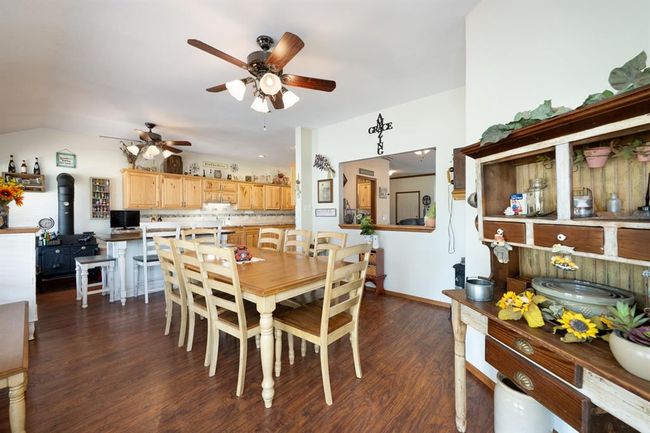 Dining room featuring baseboards, lofted ceiling, dark wood-style floors, and a ceiling fan | Image 15