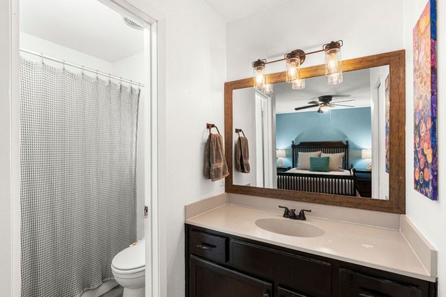 Bathroom featuring ceiling fan, connected bathroom, vanity, toilet, and a shower with shower curtain | Image 18