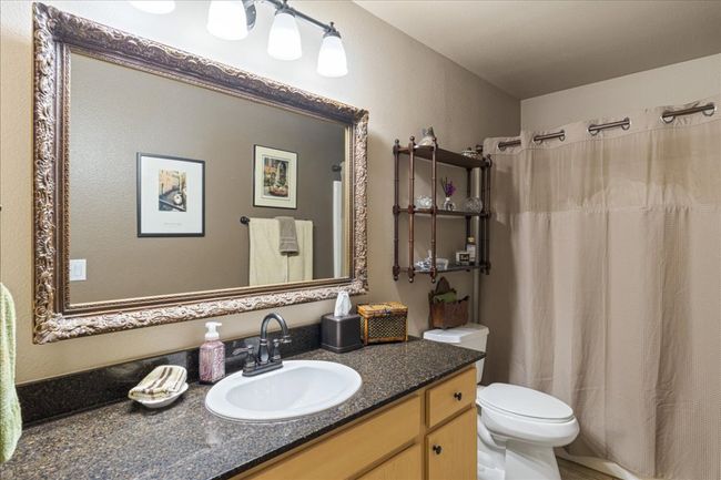 Bathroom featuring vanity, a shower with curtain, and toilet | Image 20