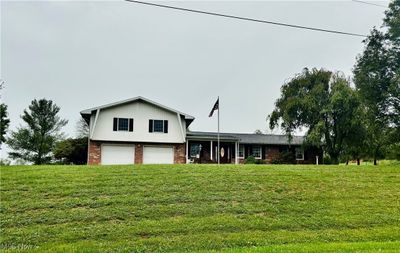 home featuring a front lawn and a garage | Image 2