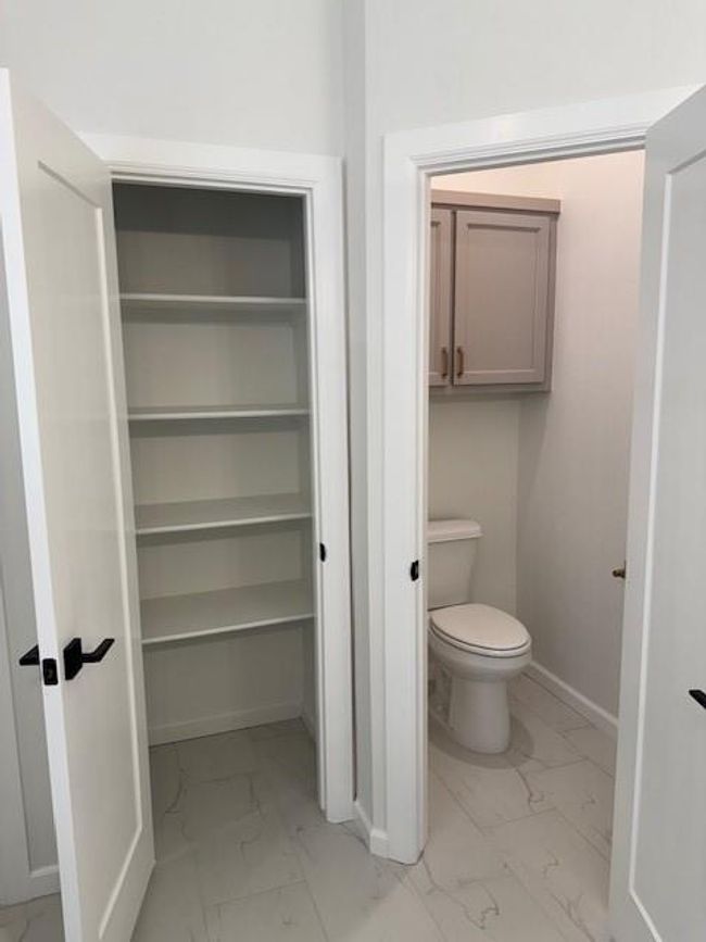 Bathroom featuring baseboards, toilet, and marble finish floor | Image 25