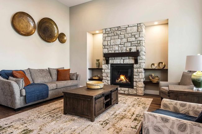 Living area with a fireplace and wood finished floors | Image 11