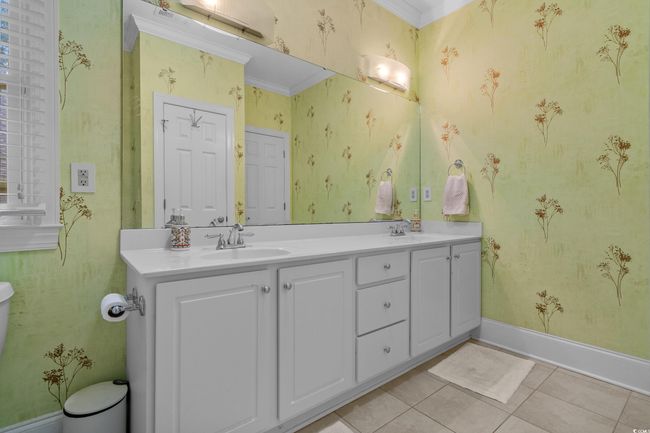 Bathroom featuring tile patterned flooring, double vanity, wallpapered walls, and ornamental molding | Image 34