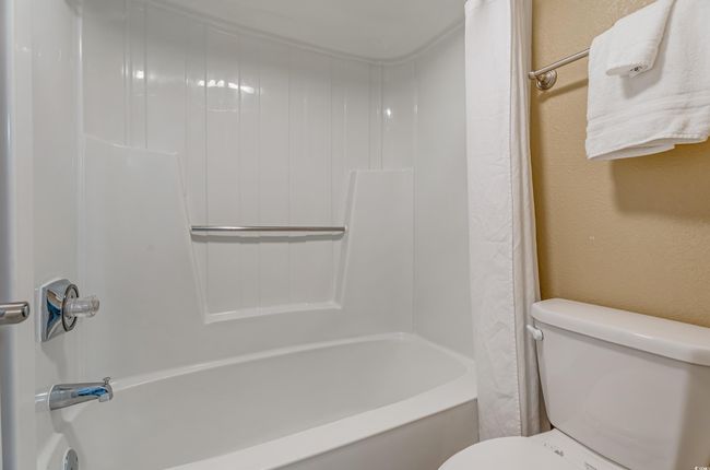 Bathroom with shower / bath combo with shower curtain and a textured wall | Image 8