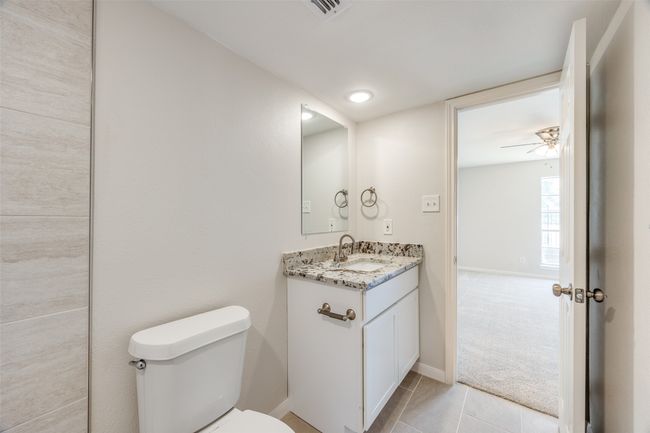 Bathroom featuring toilet, vanity, tile patterned floors, and ceiling fan | Image 24