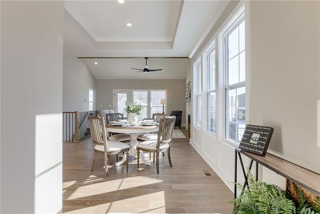Dining room featuring visible vents, light wood-type flooring, a raised ceiling, and recessed lighting | Image 4