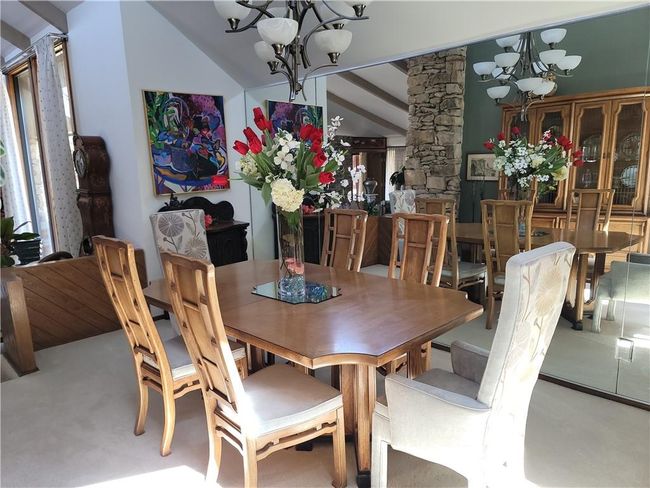 Carpeted dining room with an inviting chandelier | Image 11