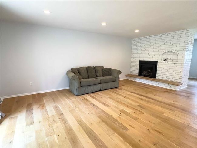 Living area featuring recessed lighting, baseboards, light wood-type flooring, and a brick fireplace | Image 16