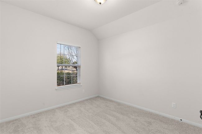 Spare room featuring baseboards, carpet floors, and vaulted ceiling | Image 8