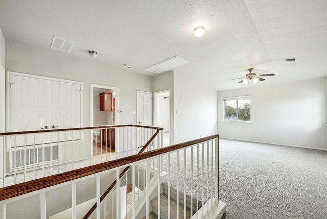 Hallway with carpet, an upstairs landing, and attic access | Image 12
