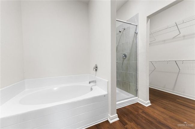 Full bathroom featuring a spacious closet, a stall shower, and wood finished floors | Image 14