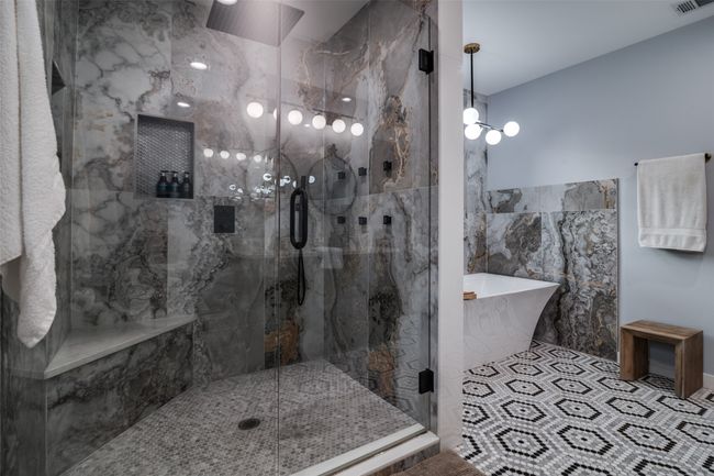 Bathroom featuring a freestanding bath, tile walls, and a marble finish shower | Image 22
