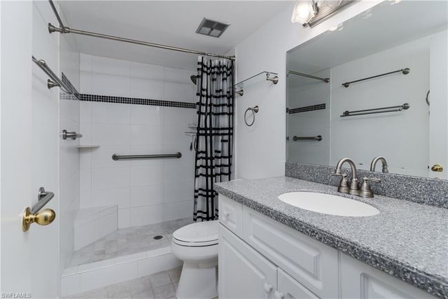 Bathroom featuring a tile shower, toilet, vanity, and visible vents | Image 14