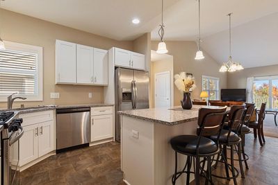 You will love the fabulous kitchen, featuring granite countertops, a spacious center island perfect for seating and storage, gas stove, and sleek stainless-steel appliances. | Image 2