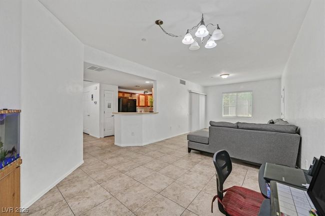 Living room with light tile patterned floors and a chandelier | Image 6