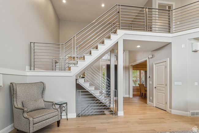 Staircase featuring a high ceiling, wood finished floors, and recessed lighting | Image 23
