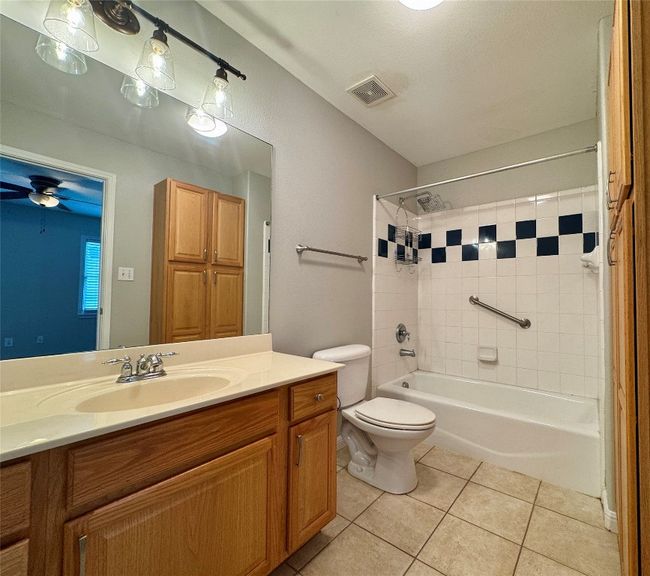 Bathroom featuring vanity, tile patterned flooring, and shower / bathtub combination | Image 17