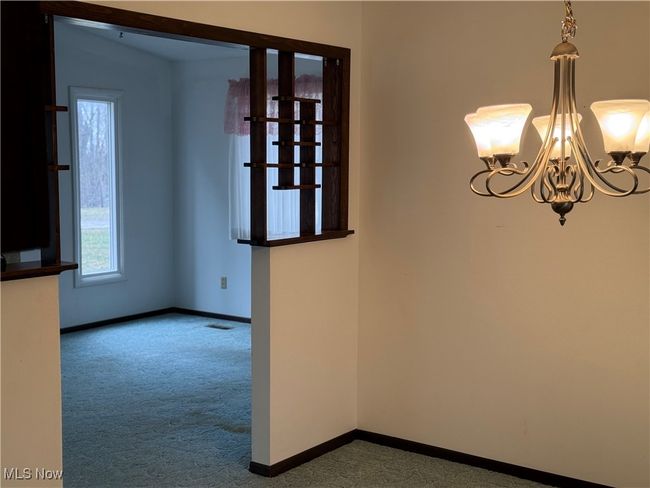 Carpeted empty room with a chandelier, visible vents, and baseboards | Image 18
