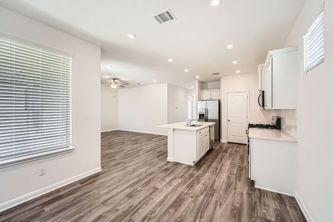 Kitchen with visible vents, a ceiling fan, backsplash, appliances with stainless steel finishes, and dark wood-style flooring | Image 9