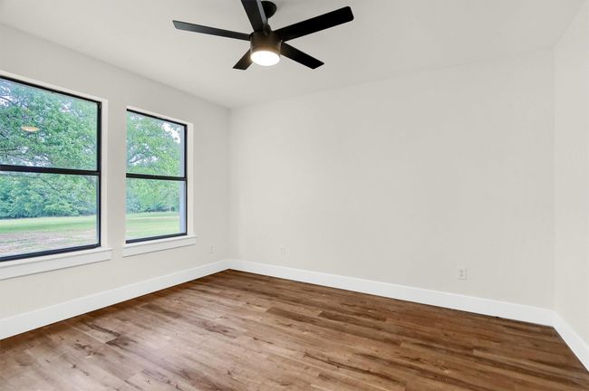 Empty room with baseboards, wood finished floors, and a ceiling fan | Image 18
