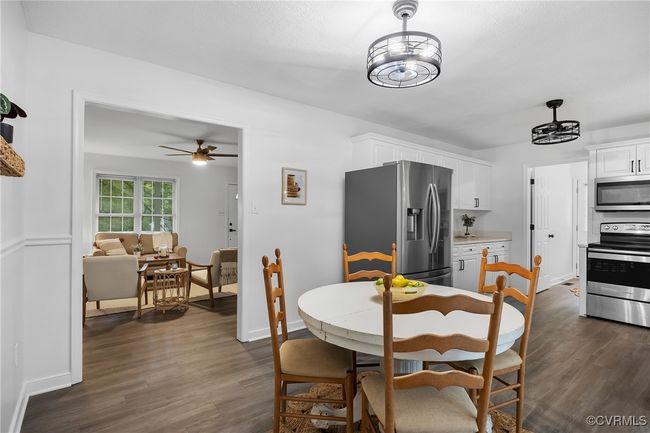 Dining space with dark wood finished floors, ceiling fan, and baseboards | Image 5