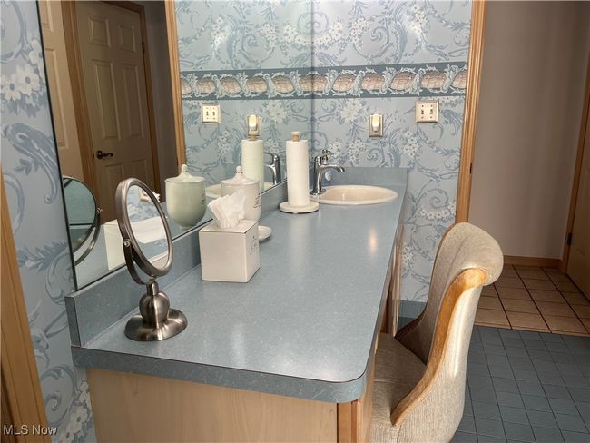 Has a large vanity with sink and an area to put on makeup. | Image 25